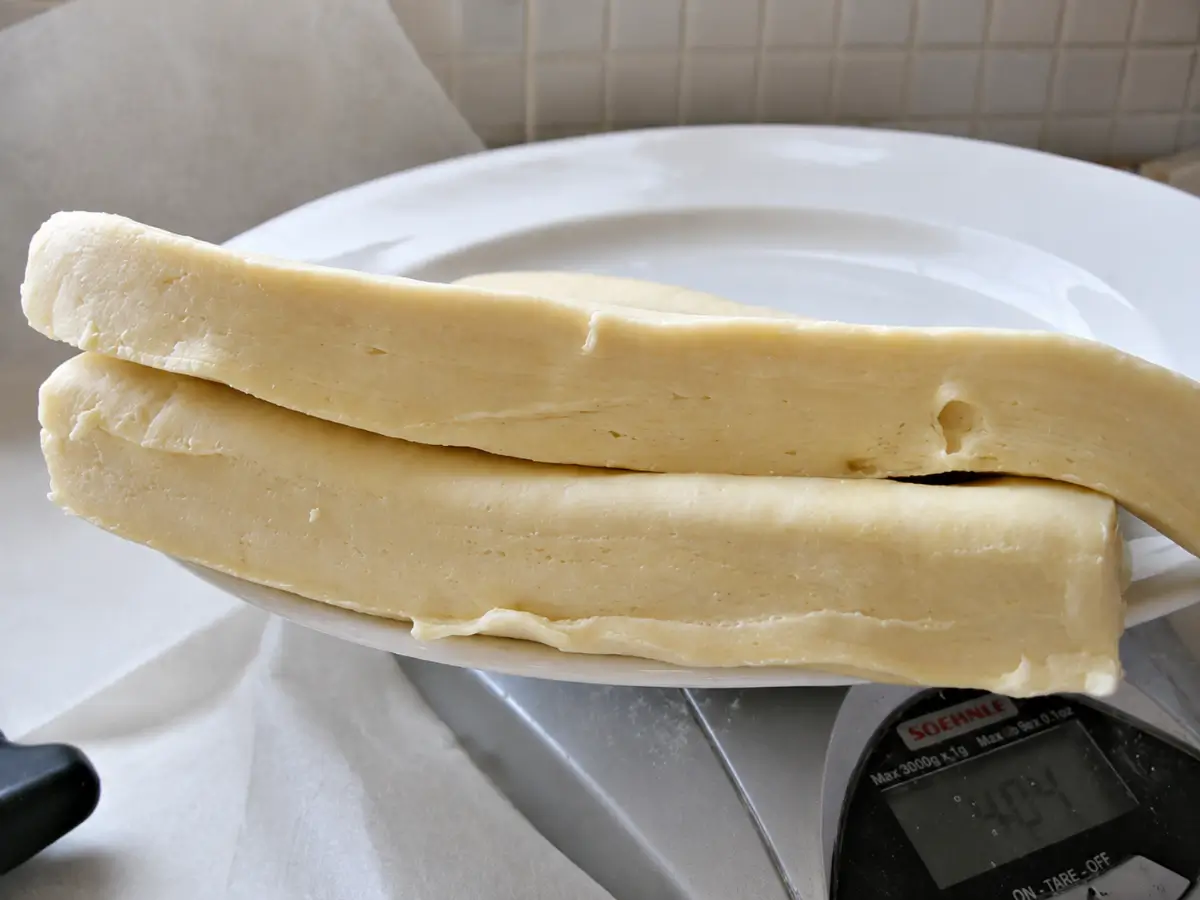 Rectangular butter block resting on a plate before being enclosed in dough.