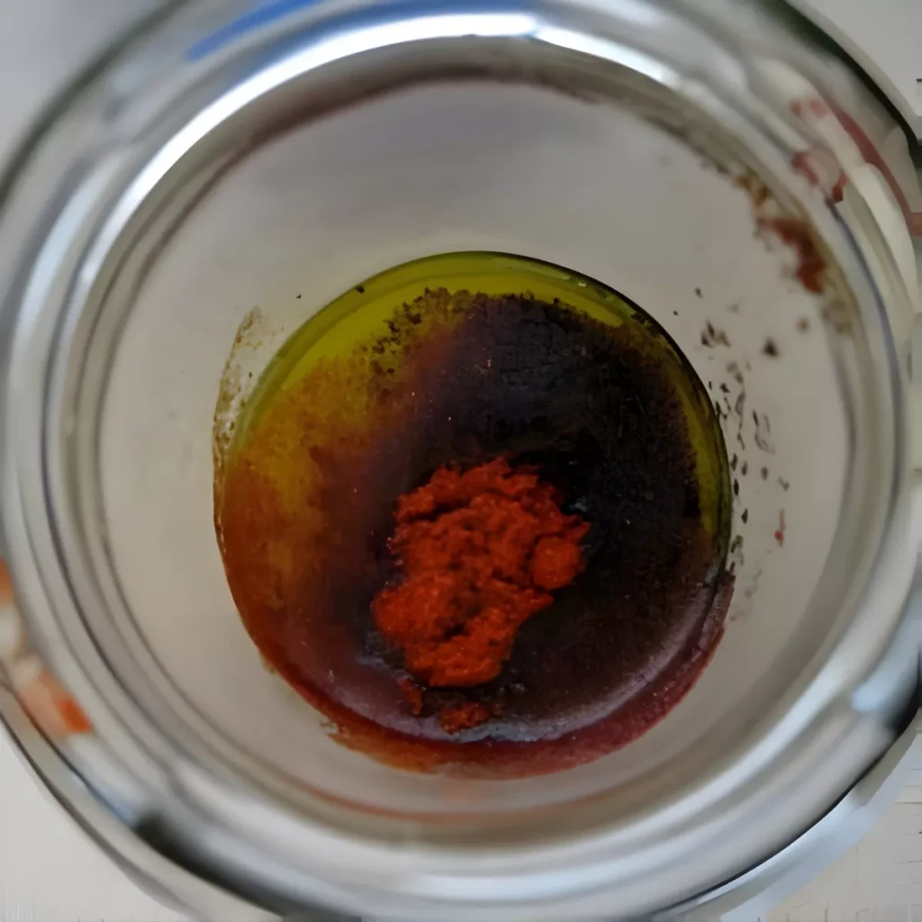 A close-up of sumac dressing ingredients in a jar.