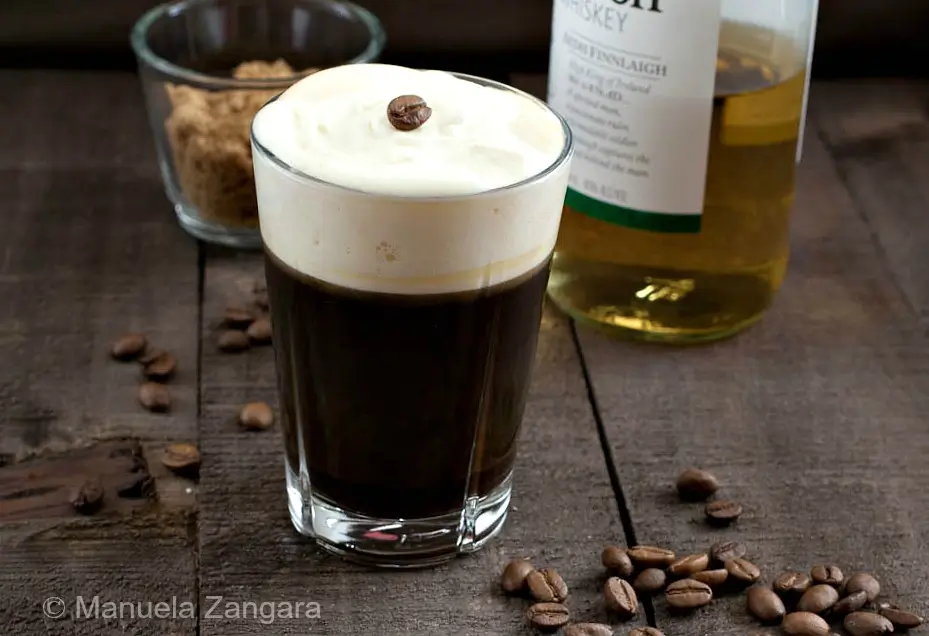 Finished Irish Coffee with whipped cream and a coffee bean on top.