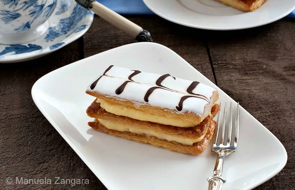 Finished mille-feuille slice on a white plate with a fork.