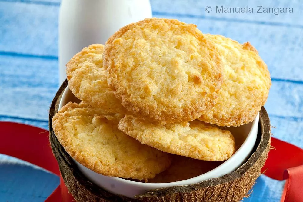 Close-up of golden, chewy coconut cookies in a bowl.