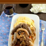 Close-up of pork ribs, sausages, and cabbage stew with polenta.