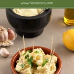 Spanish potatoes with aioli served in a terracotta dish.