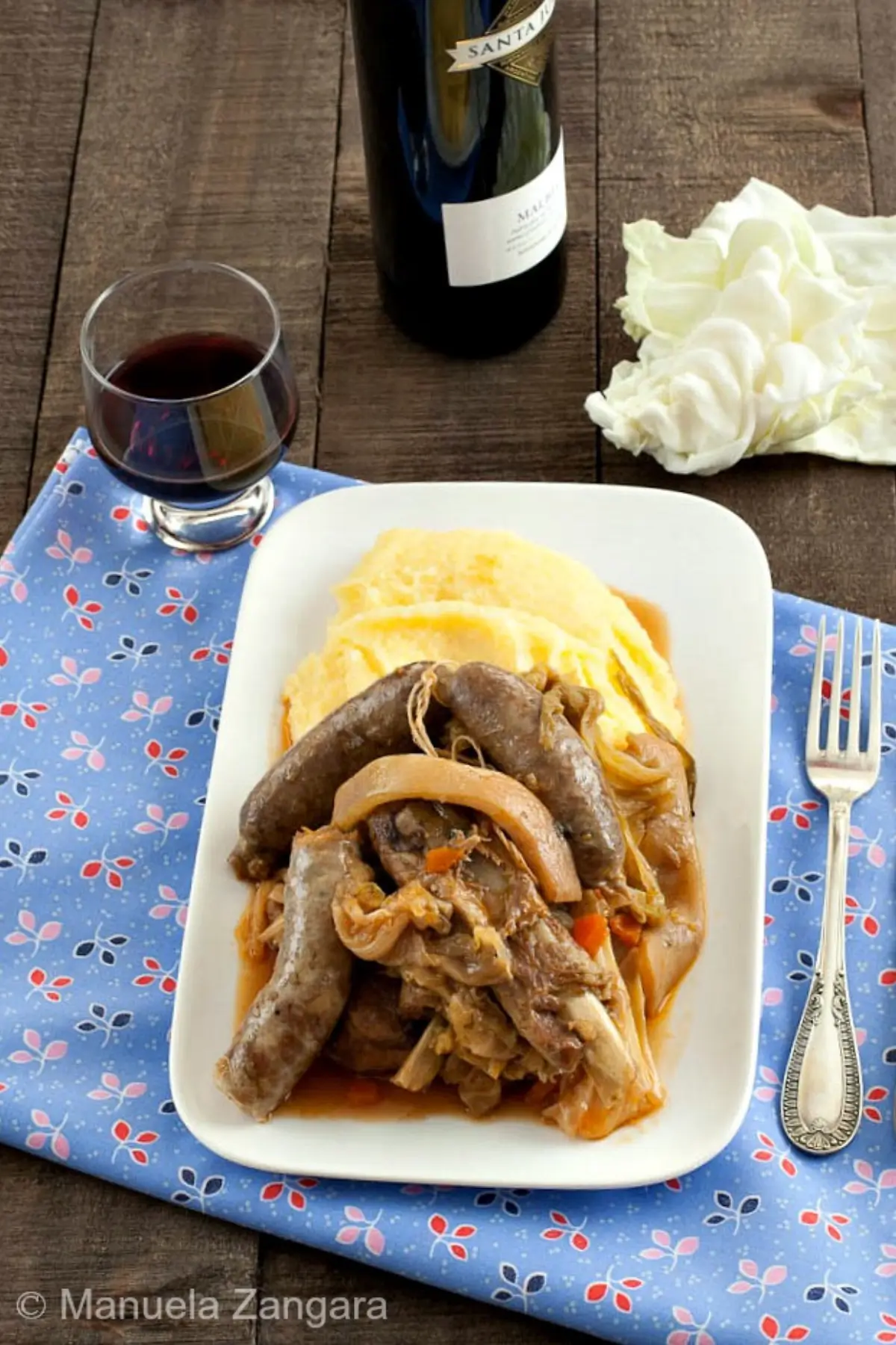 Cassoeula pork and cabbage stew with sausages and pork rind served with creamy polenta on a plate.