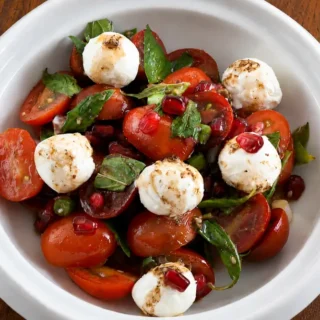 Fresh tomato and labneh salad served with pomegranate dressing, cherry tomatoes and toasted flatbread.