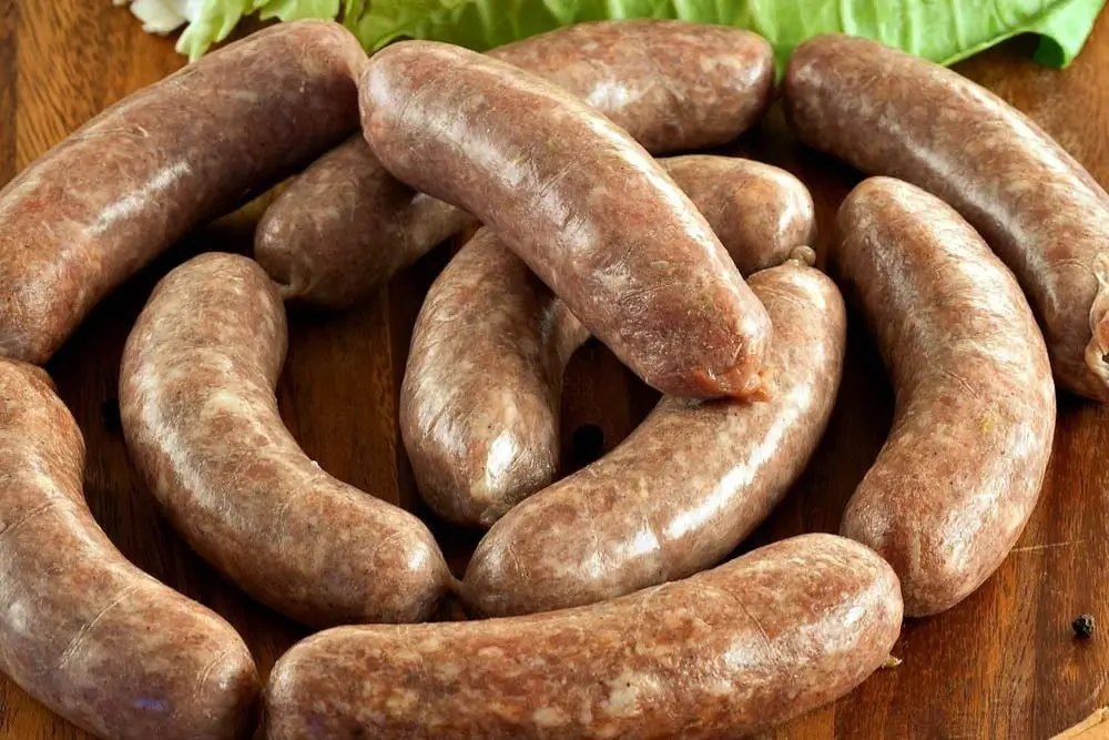 Close-up of traditional Northern Italian Verzini sausages with natural casings and rustic styling.