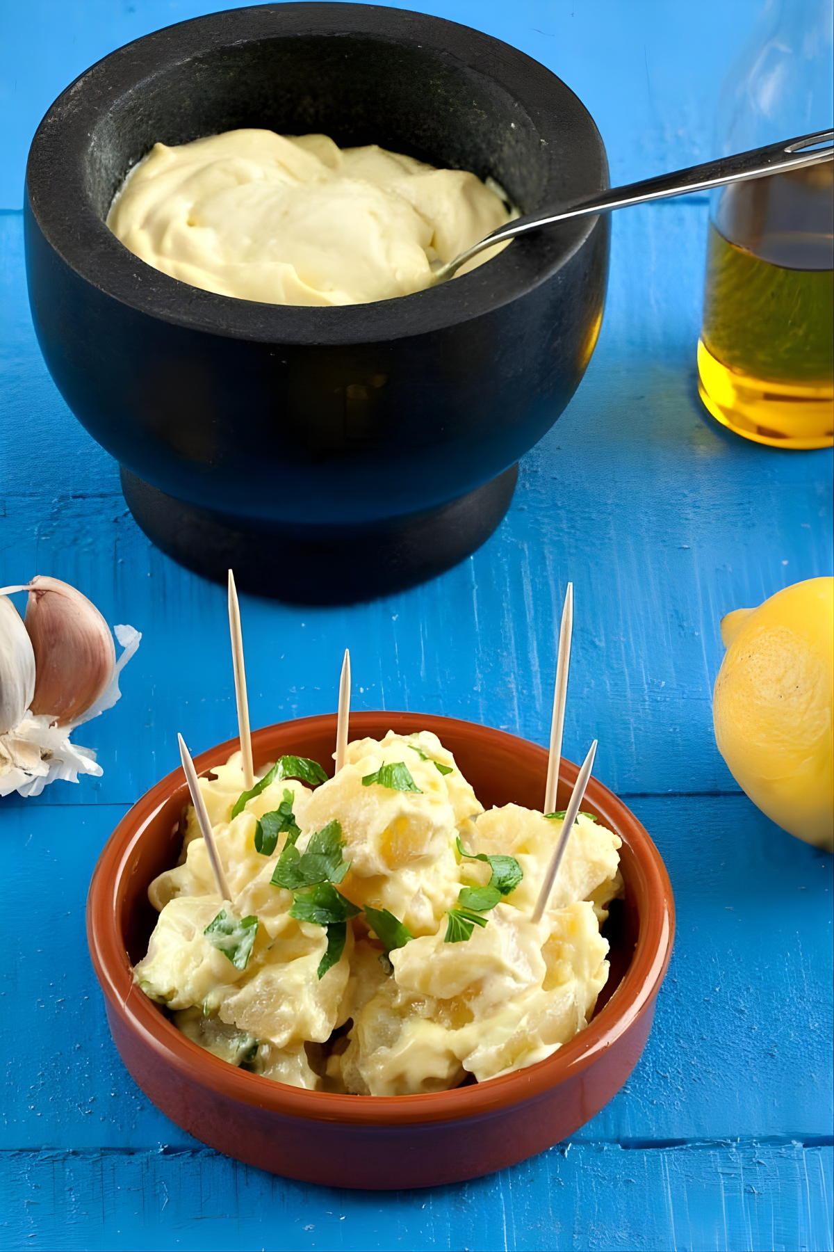 Bowl of Patatas Alioli served with garlic, lemon, and aioli on a table.