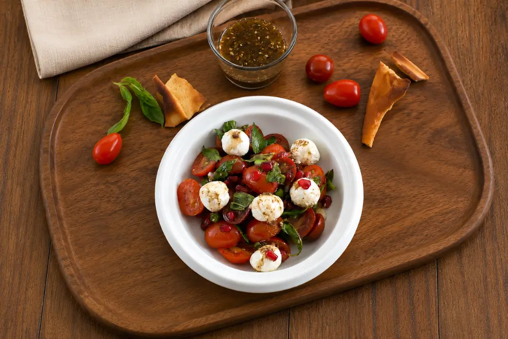 Tomato Salad with Labneh and Pomegranate Dressing topped with creamy labneh, fresh mint and pomegranate arils.