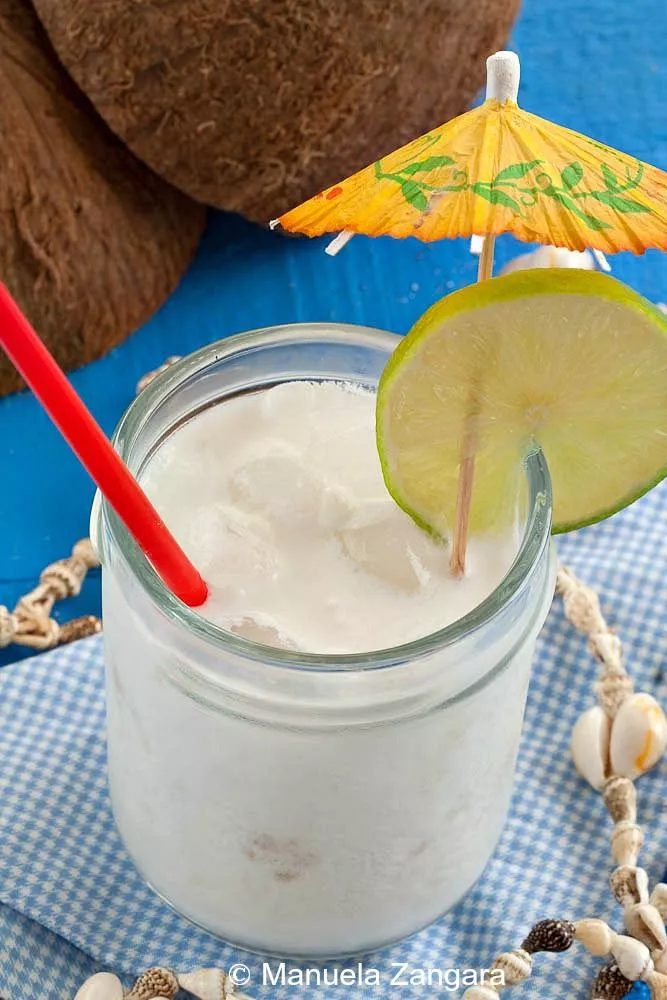 Close-up of creamy Coco Loco cocktail with coconut shells in background.