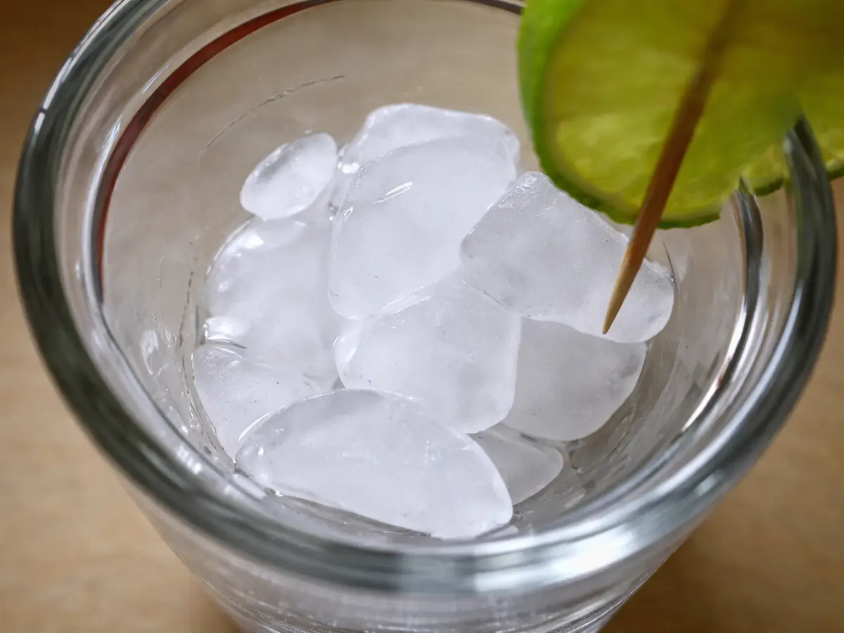 Clear glass filled halfway with ice cubes.