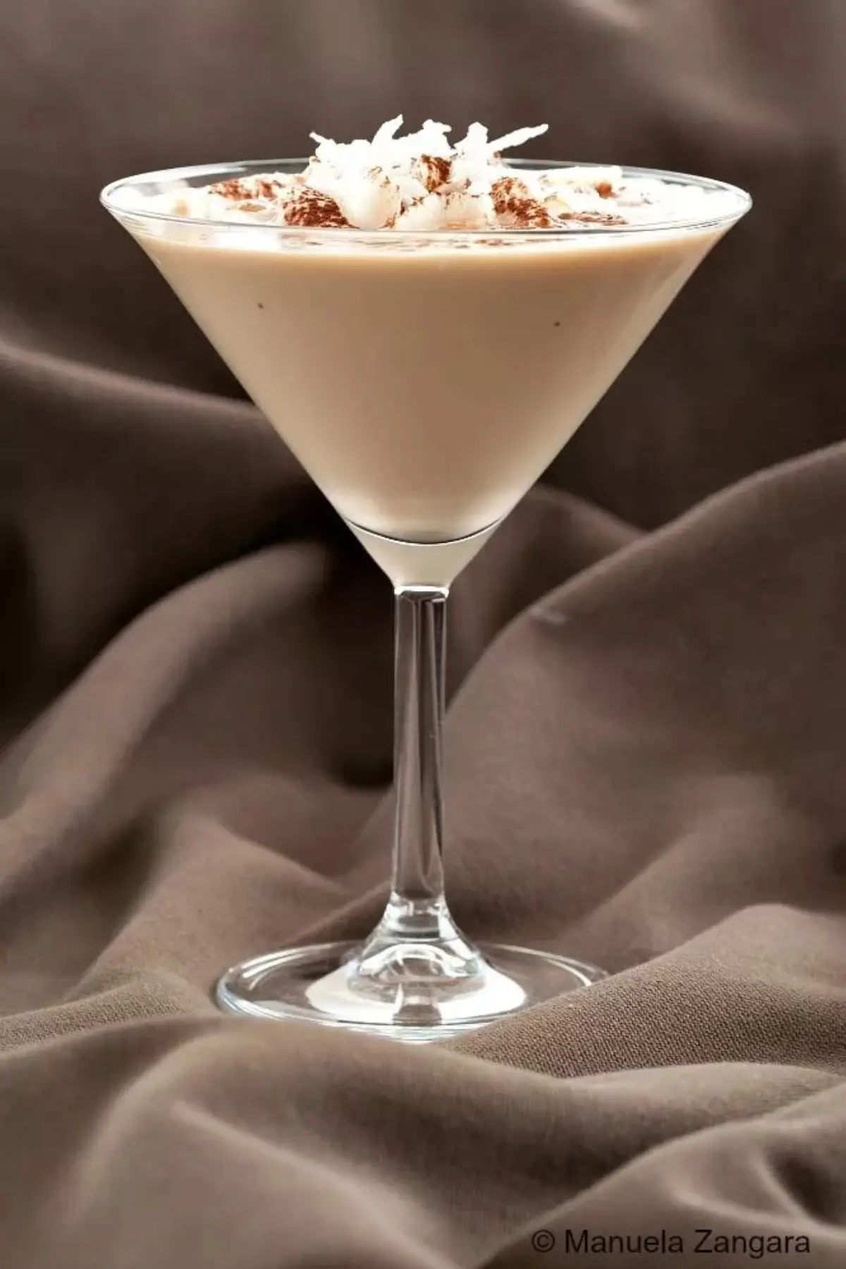 Dessert-style coconut cocktail served in a classic martini glass.