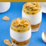Layered yoghurt and passion fruit in a glass, finished with cornflakes on top.