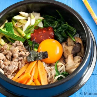 Bibimbap bowl ready to be mixed at the table.