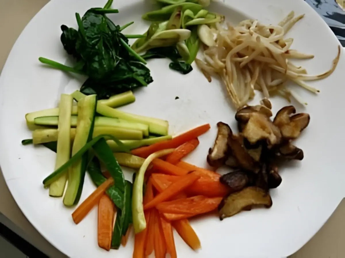 Prepared vegetables for bibimbap arranged on a plate.