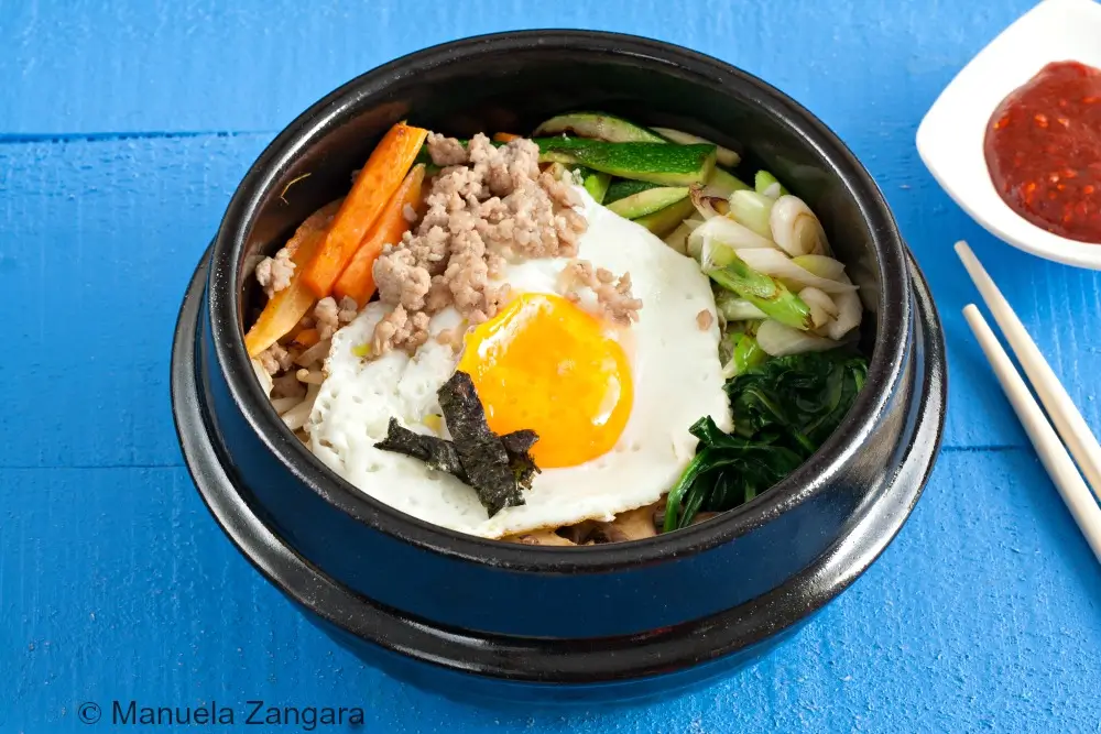Bibimbap with fried egg, vegetables, and gochujang.