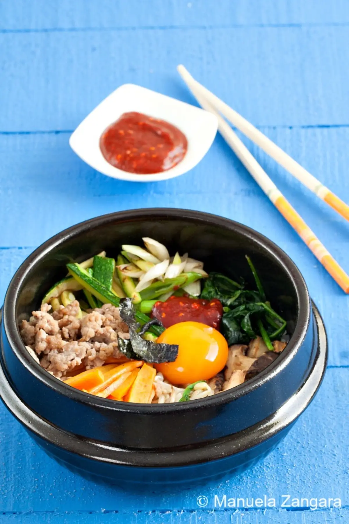 Dolsot bibimbap with raw egg yolk and gochujang.