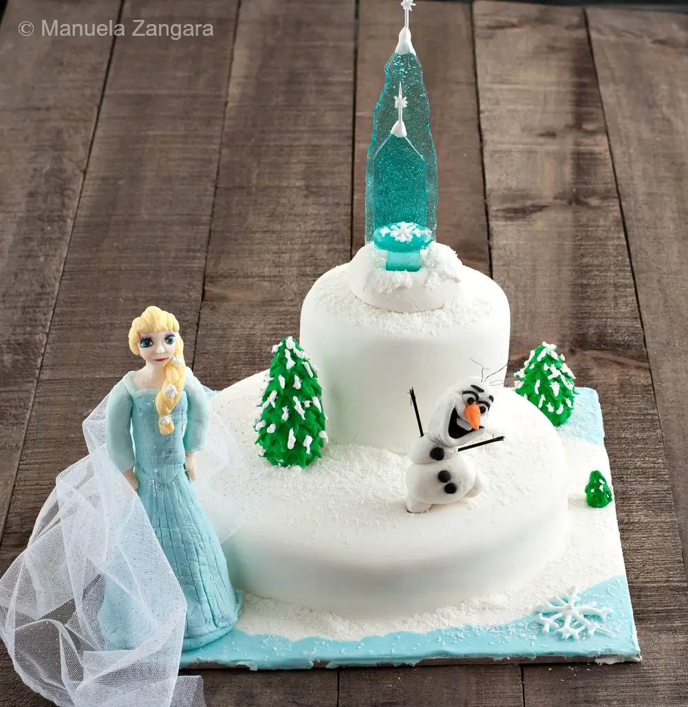 Full Frozen-themed cake view with Elsa, Olaf, sugar castle, and fondant trees.