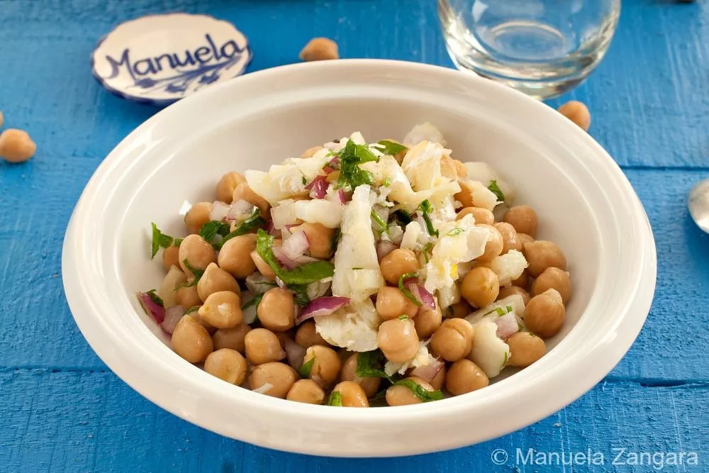 Close-up of Portuguese salted cod and chickpea salad with parsley and red onion.