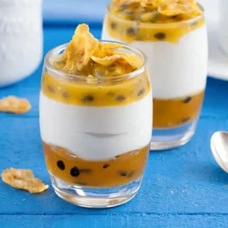 Tropical verrine with yoghurt, passion fruit and cornflakes served in a small glass.