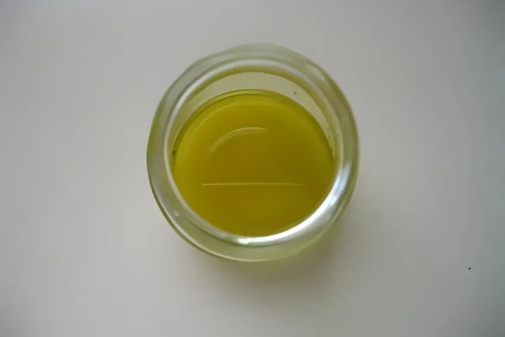 Homemade olive oil vinaigrette in a small glass jar for Salada de Bacalhau e Grão.