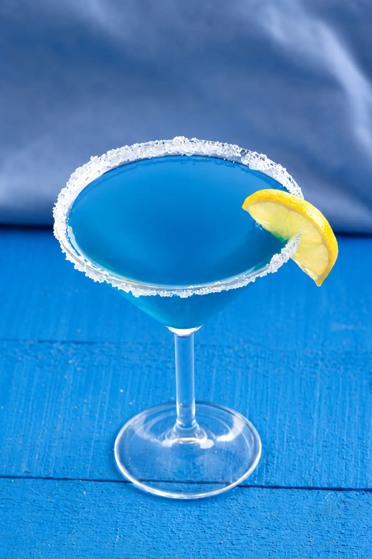 Overhead view of a Blue Daiquiri with ice cubes and a clear straw.