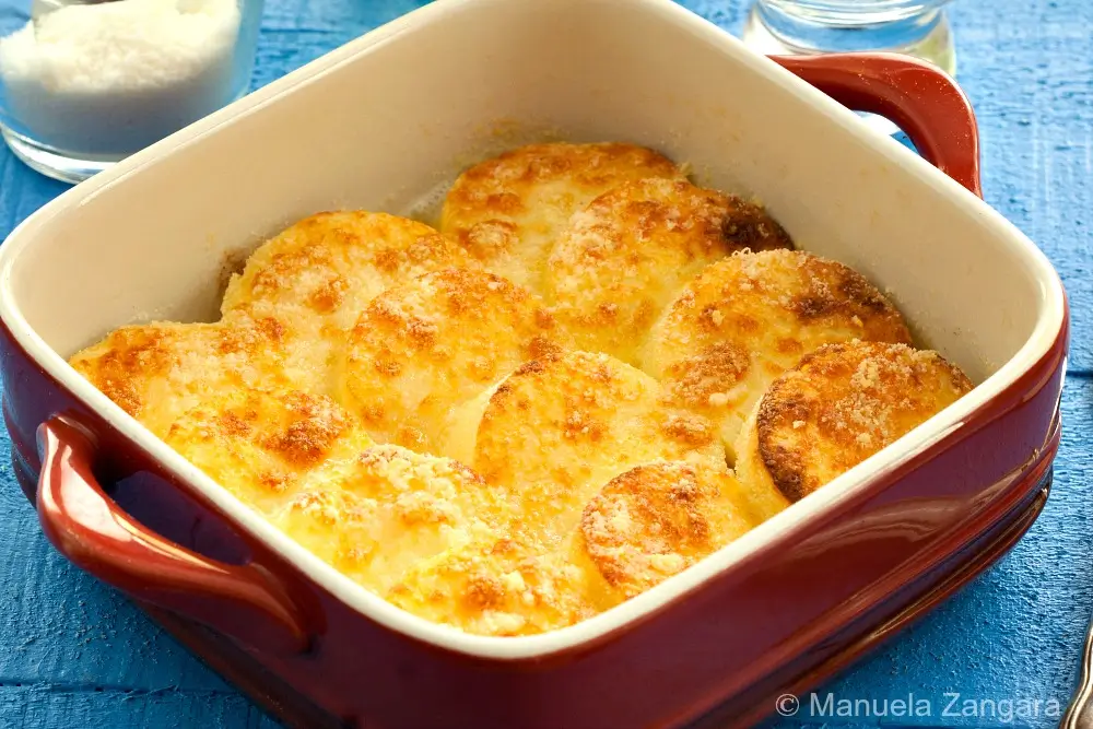 Close-up of golden baked gnocchi alla Romana in baking dish.