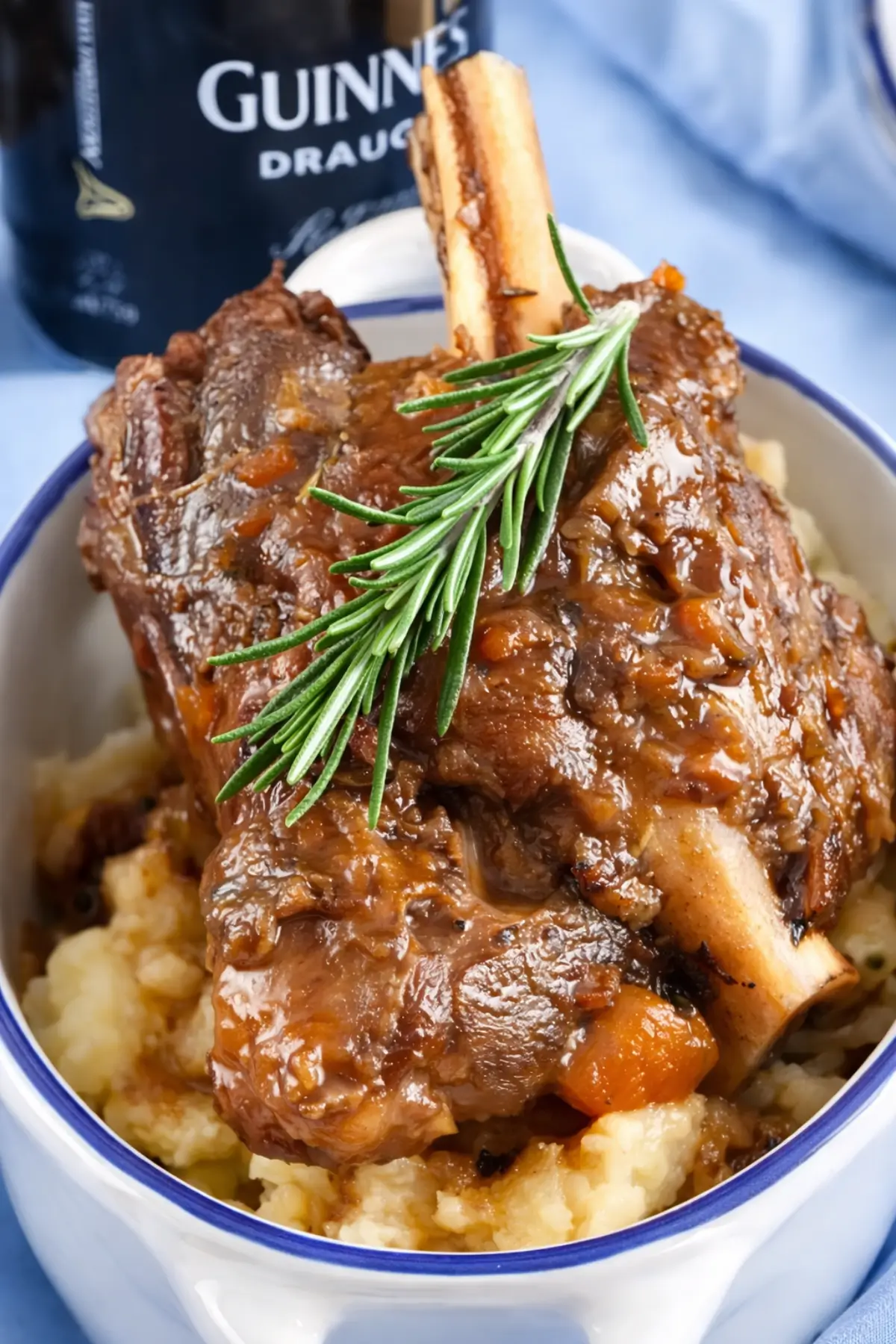 Guinness braised lamb shanks close-up with gravy and rosemary.
