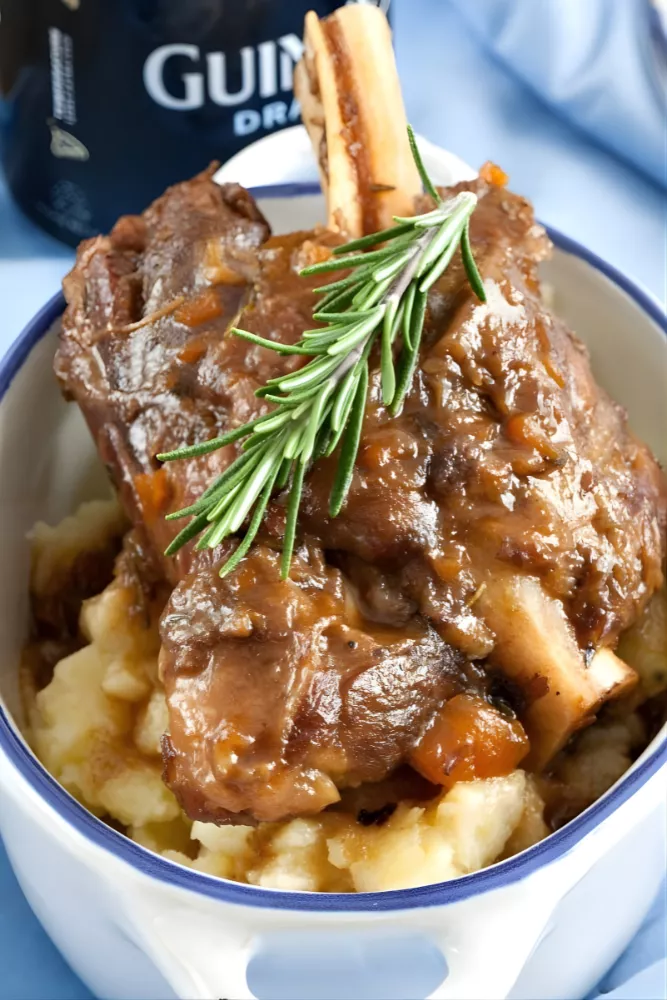 Featured image of tender Guinness braised lamb shank with mashed potatoes and rosemary.