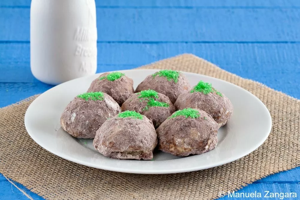 Plate of Troll Cookies coated in cocoa sugar and topped with green moss sugar sprinkles.