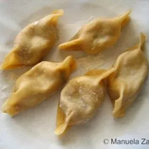 Shaped Casoncelli arranged on a tray before cooking.