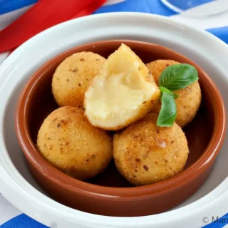 Close-up of fried cheese bitterballen with crisp coating.