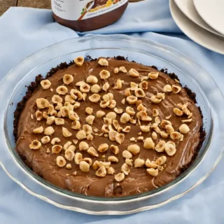 Chilled chocolate hazelnut pie topped with chopped toasted hazelnuts.