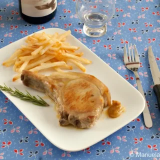 Pan-Fried Pork Loin Cutlet plated with fries and rosemary on a white dish.