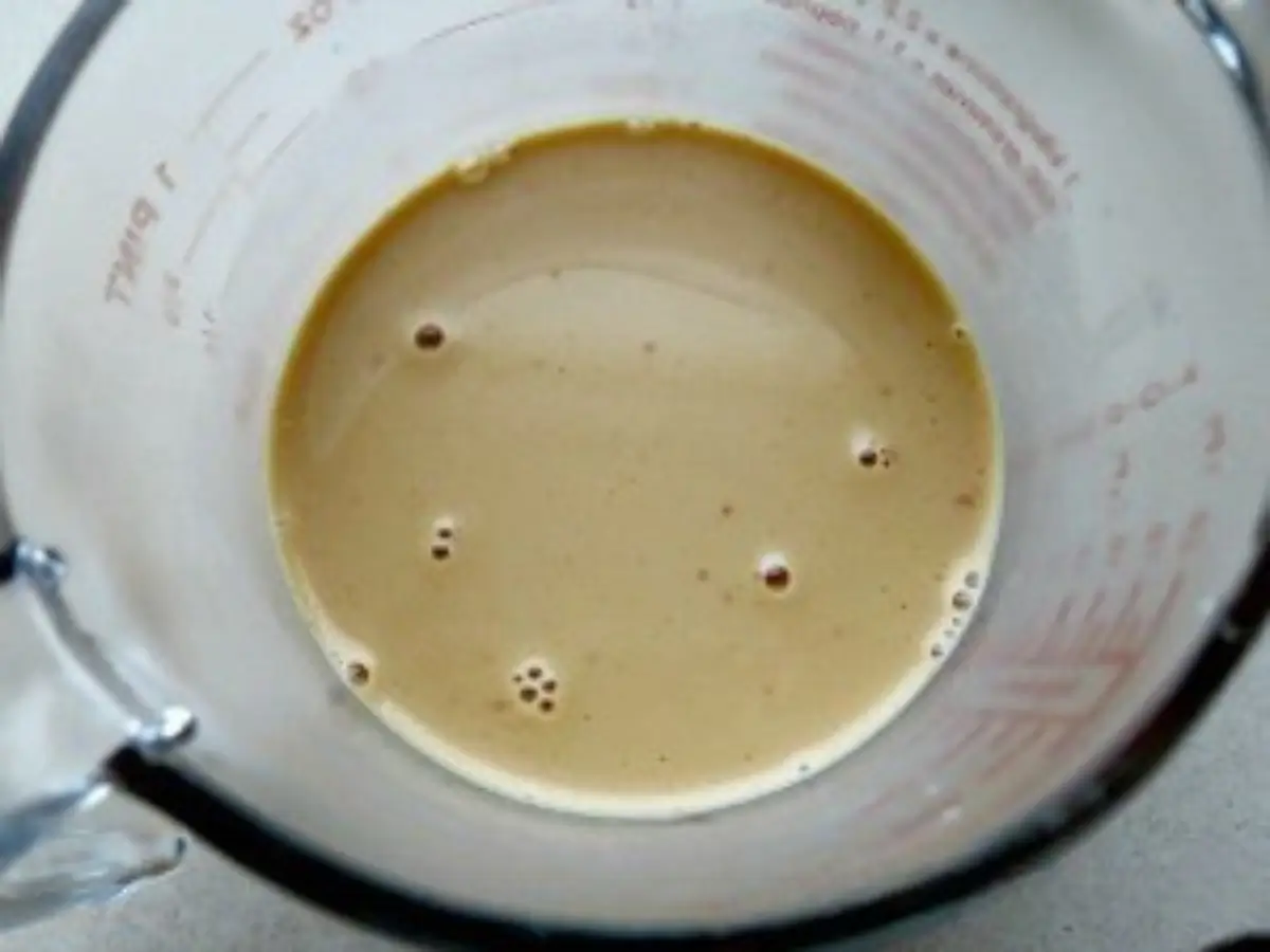 Smooth caramel liqueur mixture resting in a measuring cup.
