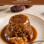 Sticky date pudding on a plate, topped with warm butterscotch sauce.