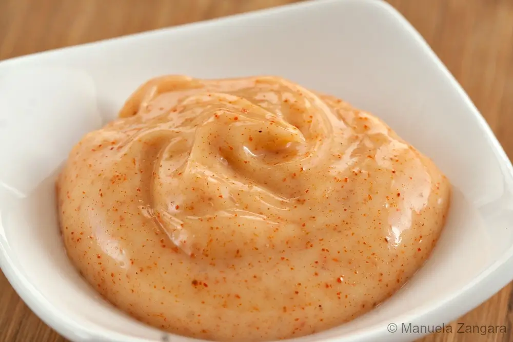 Close-up of creamy paprika mayo served in a small white dish.