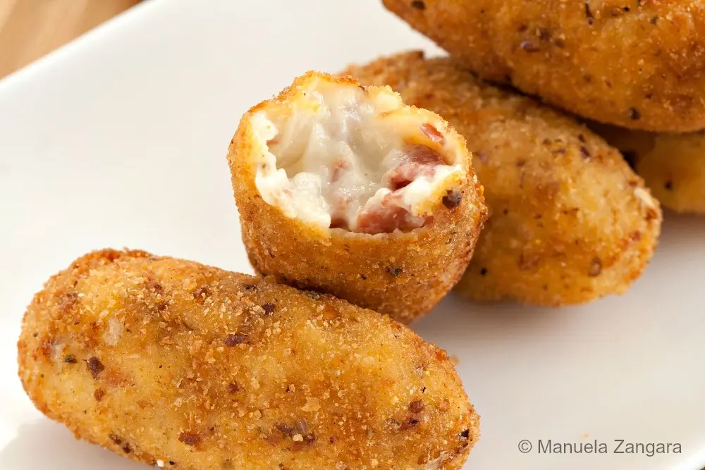 Close-up of a Serrano croquette with the creamy ham filling exposed.