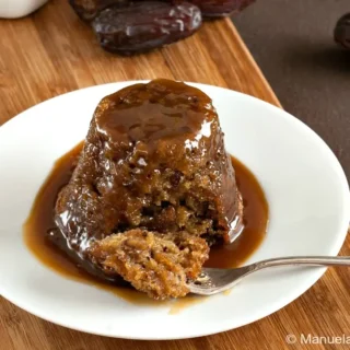 Close-up of sticky date pudding covered in rich butterscotch sauce.