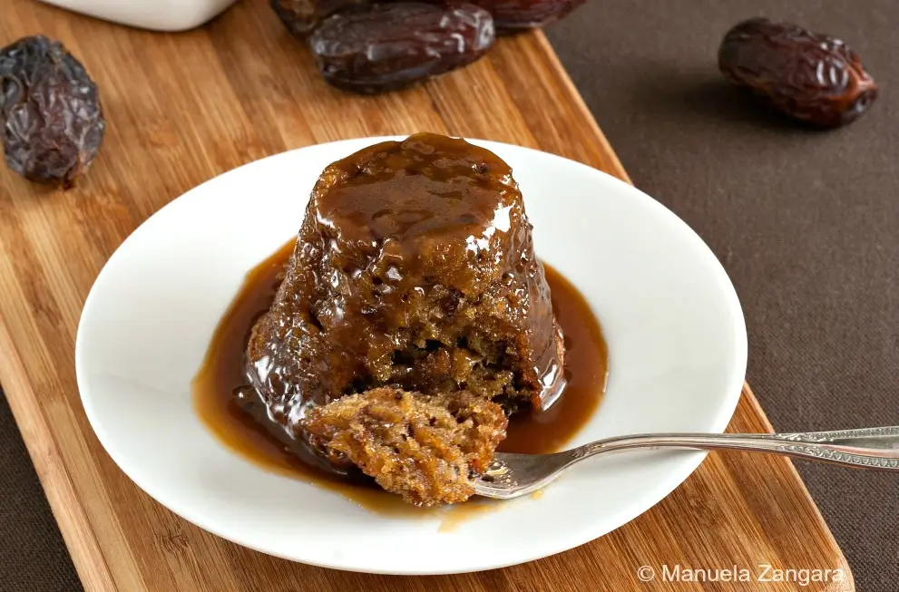 Close-up of sticky date pudding covered in rich butterscotch sauce.