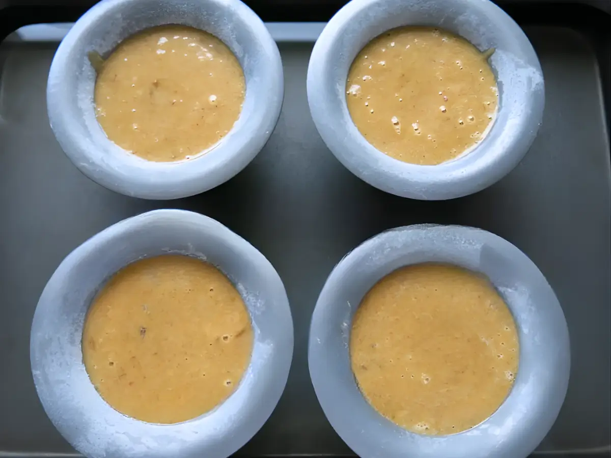 Sticky date pudding batter poured into individual moulds.