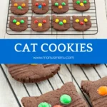 Chocolate cat cookies cooling on a wire rack, decorated with bright candy pieces.