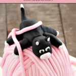 Finished Playful Kitten Cake featuring a black fondant kitten on a pink yarn ball and white fondant base.