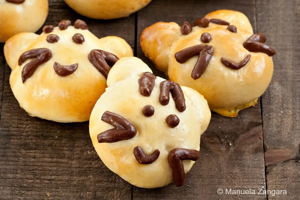 Group of baked cat-shaped bread buns arranged together.