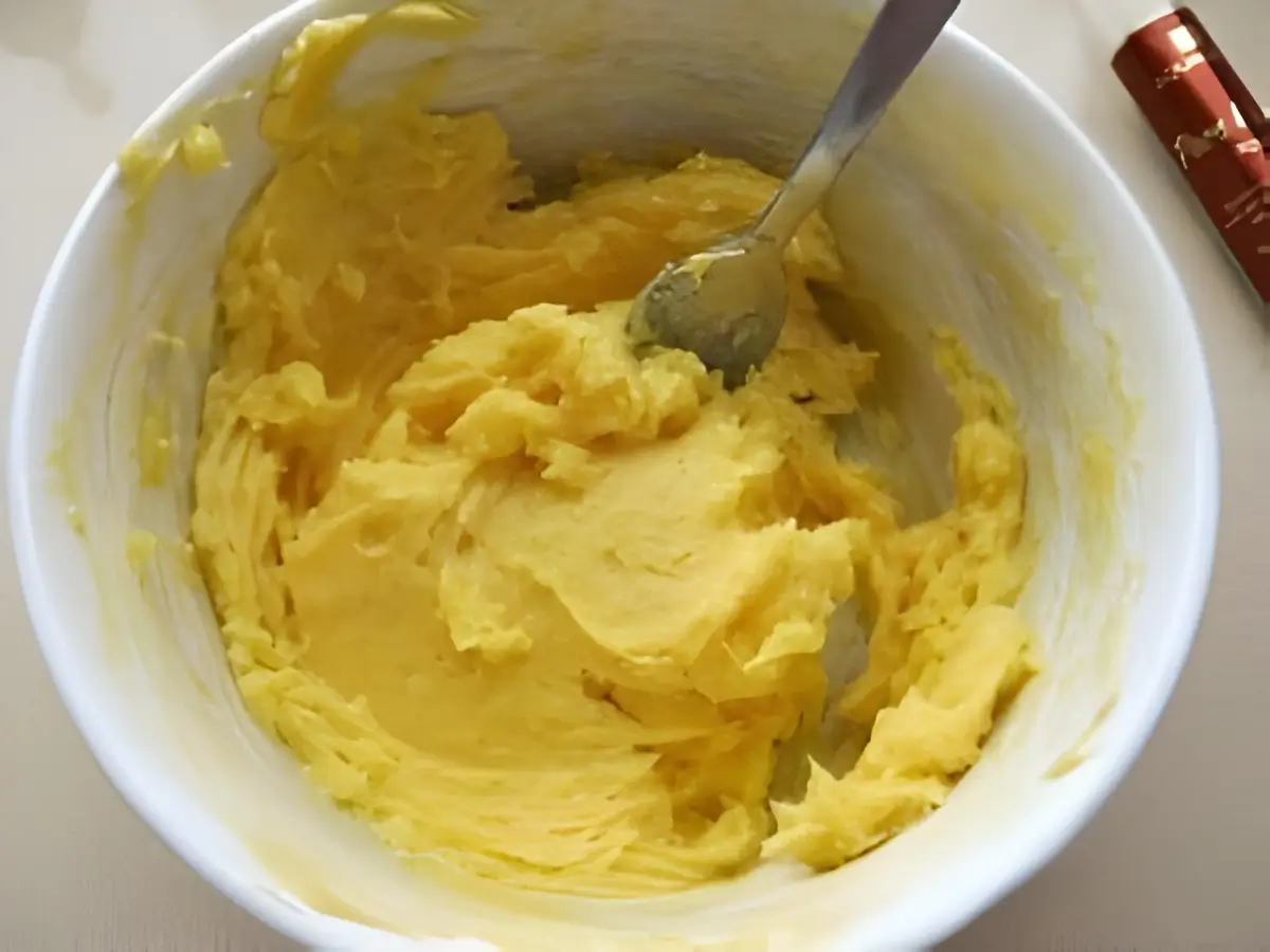 Bowl of yellow beurrage mixture made with butter, honey, vanilla, and melted white chocolate