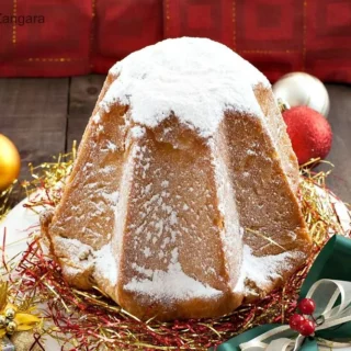 Whole Pandoro dusted with icing sugar, placed on a festive plate decorated with ribbons and tinsel.