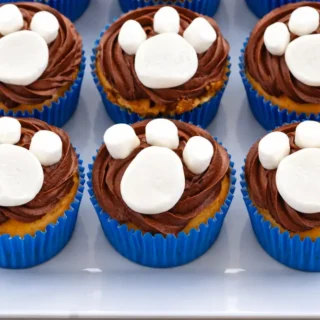 Paw Print Cupcakes decorated with chocolate icing and marshmallow paw shapes arranged on a serving plate.