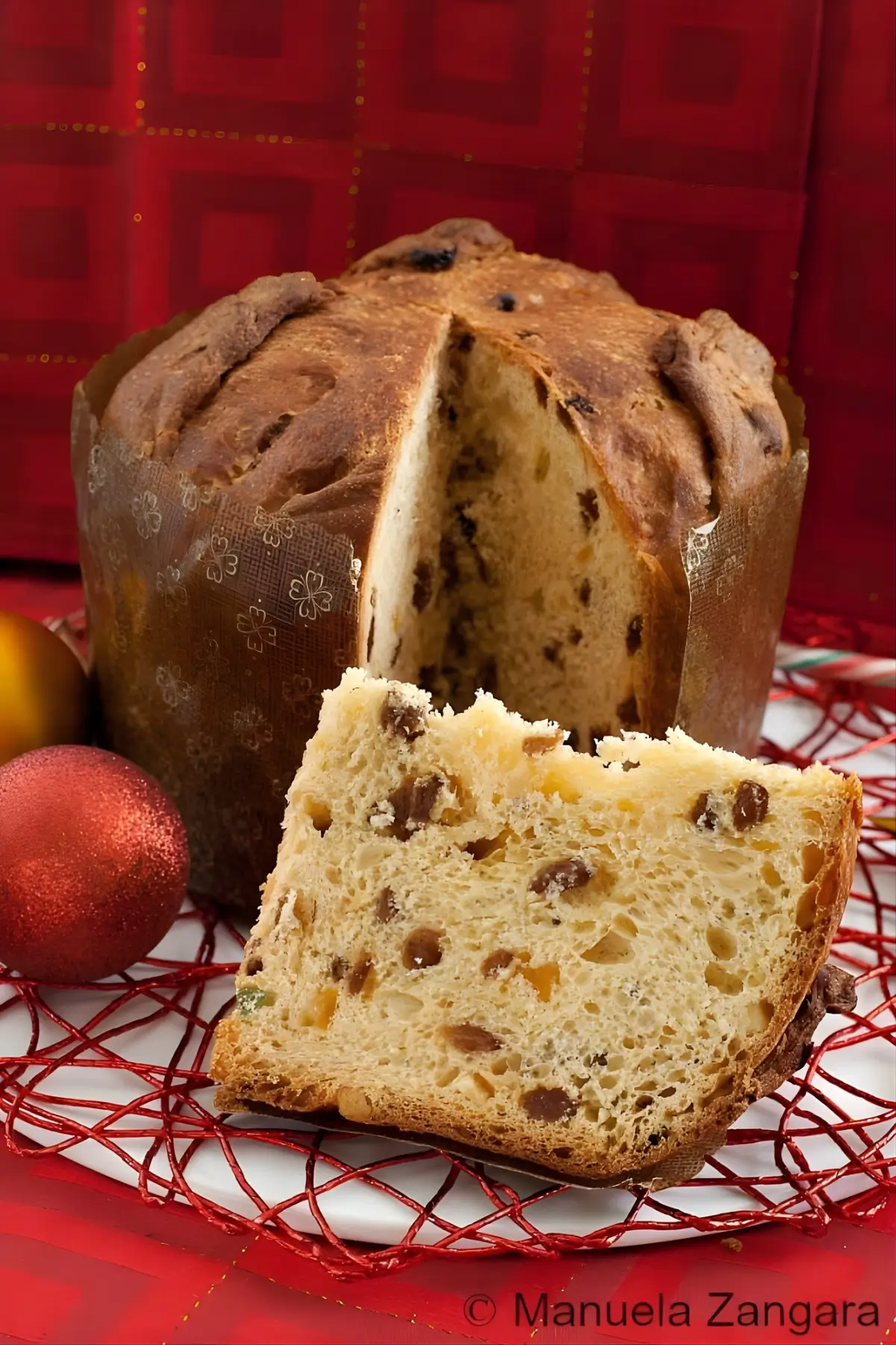 Classic Italian Panettone with raisins and candied fruit, sliced to show its texture, served on a holiday table.