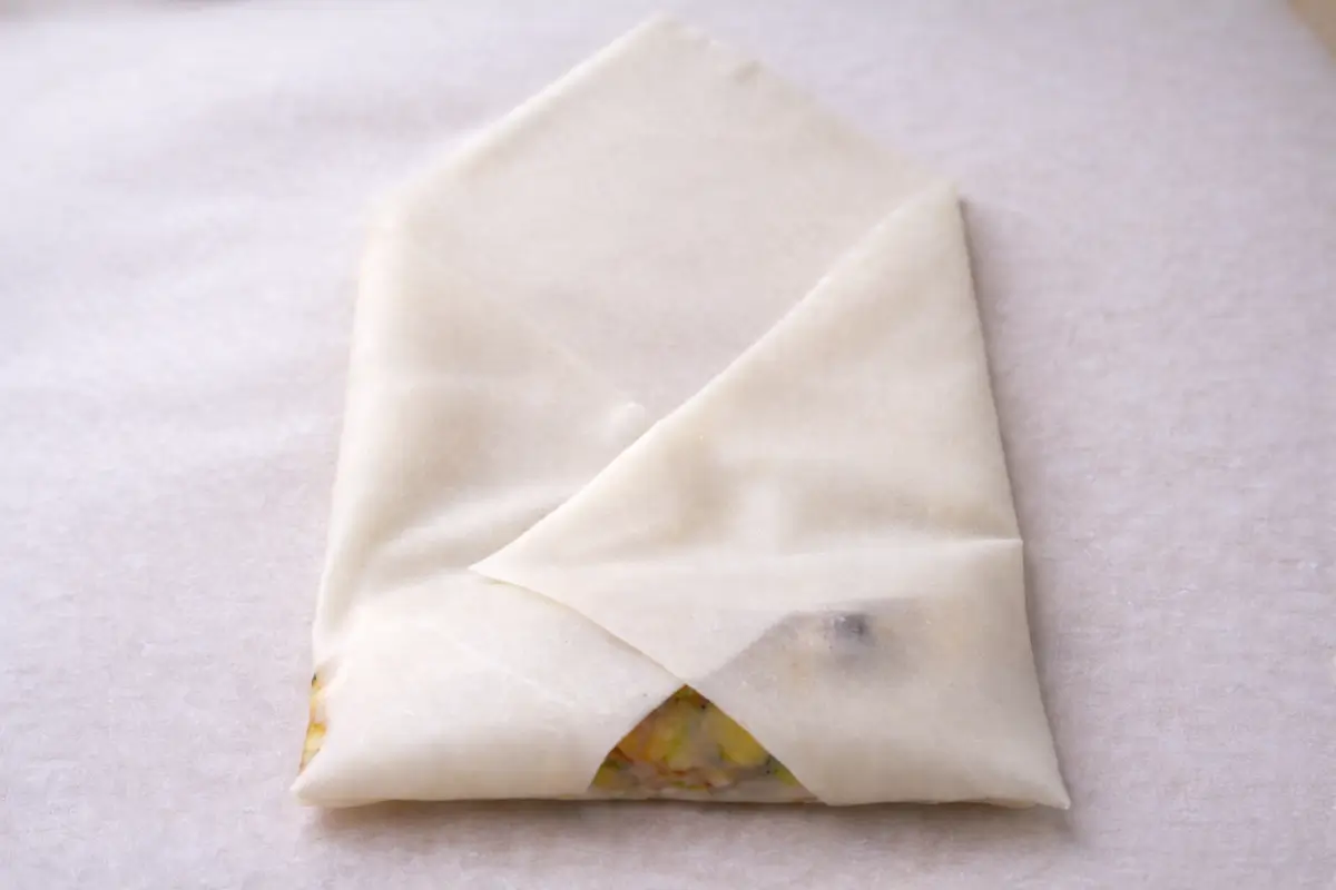 Spring roll wrapper folded over the filling.