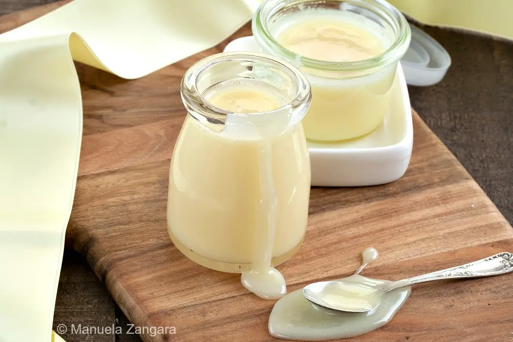 Close-up of homemade condensed milk in a glass jar.