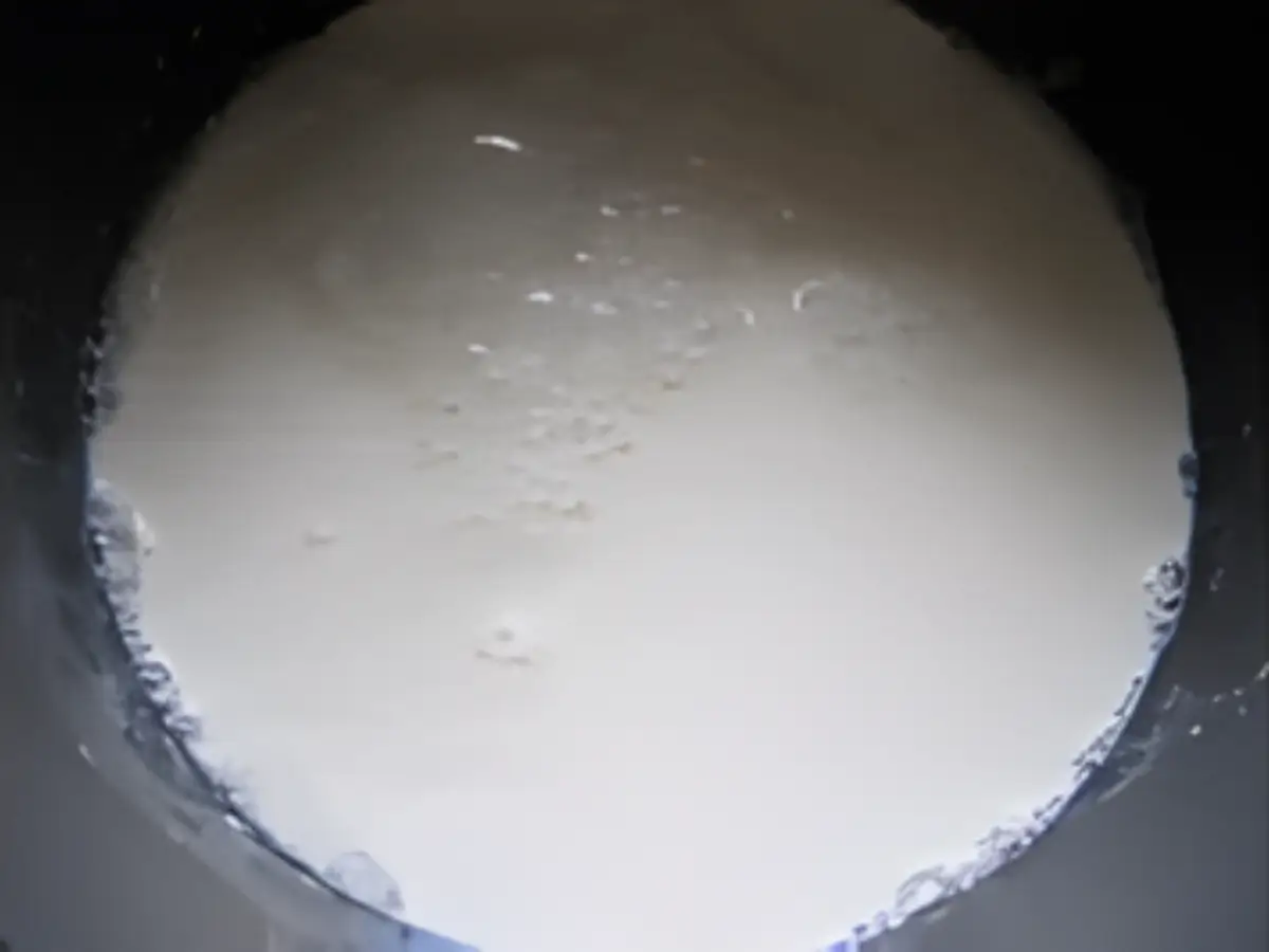 Milk simmering in a pan during the early reduction stage.